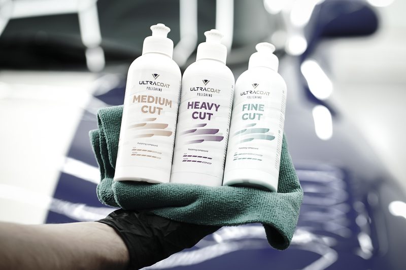 Three Ultracoat polishing compounds — Medium Cut, Heavy Cut and Fine Cut — held against a sports car bonnet, representing the Ultracoat polishing range